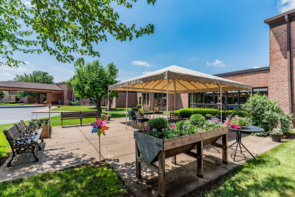 outdoor patio with covered area, garden, and lush green landscape at Ephrata Manor