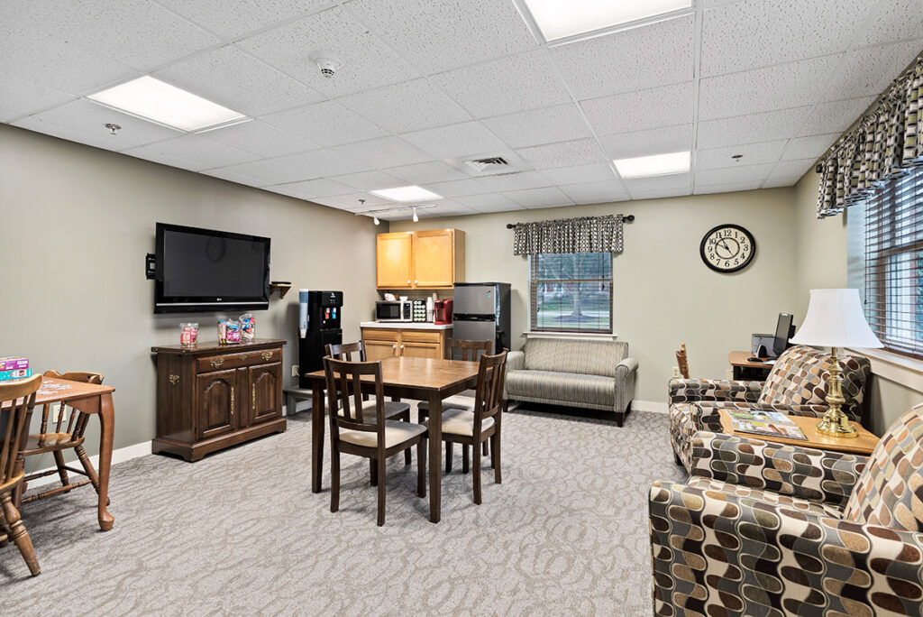 table, chairs, couches, tv in personal care room at Lebanon Valley Home