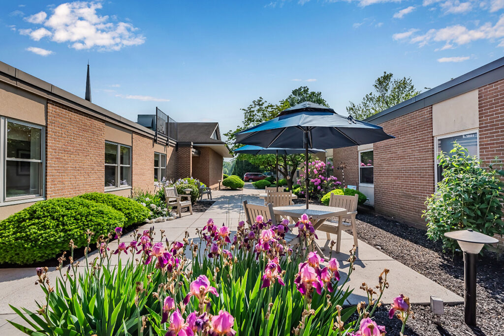 view of outdoor patio with flowers, a table, and umbrella at Lebanon Valley Home