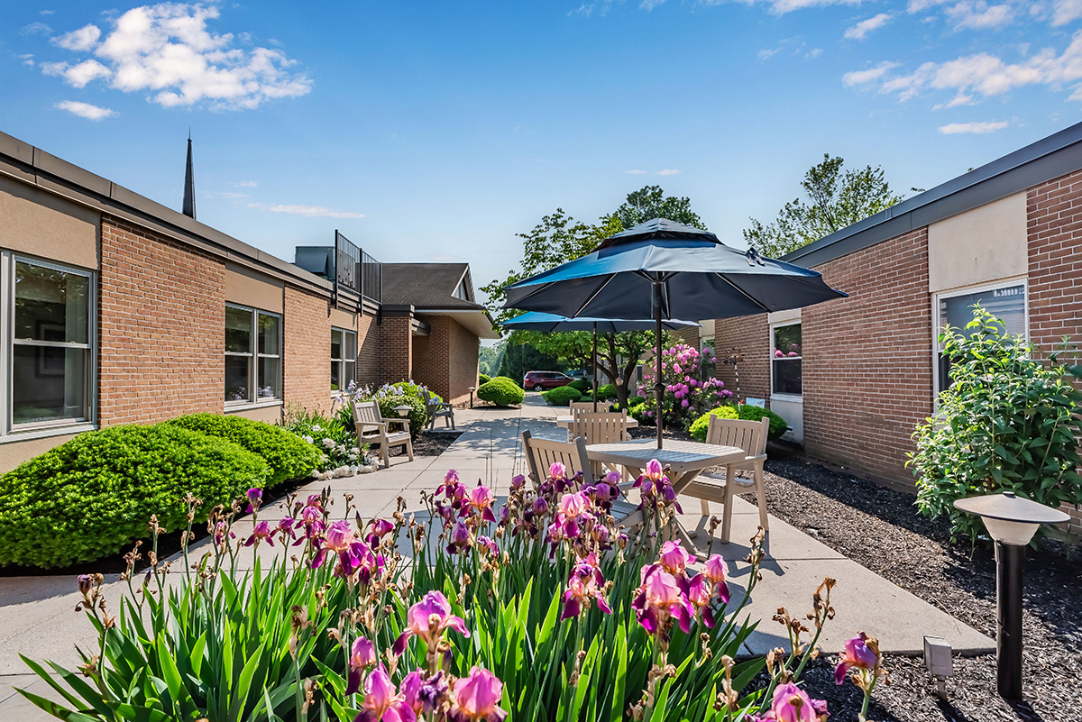 beautiful outdoor setting with flowers, an umbrella and chairs at Lebanon Valley Home